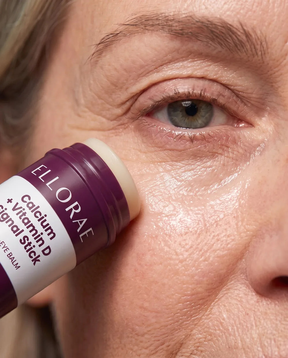 Close-up of the balm stick gliding under the eye and leaving a smooth, hydrated layer